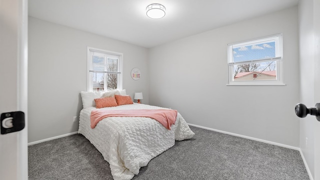 bedroom featuring dark carpet and baseboards