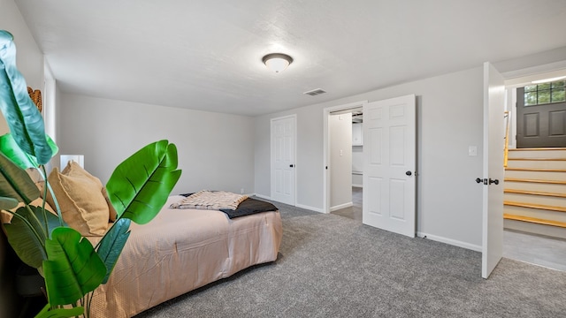 bedroom featuring carpet flooring, visible vents, baseboards, and a textured ceiling