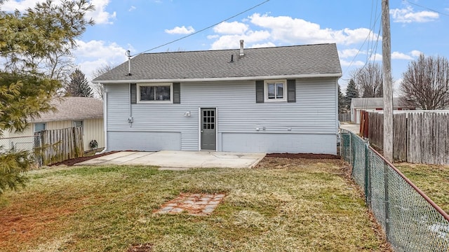 rear view of house featuring a shingled roof, a fenced backyard, a yard, and a patio