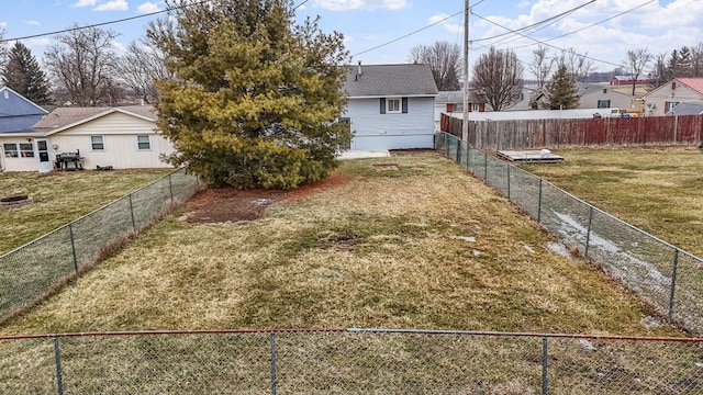 view of yard featuring a fenced backyard and a residential view