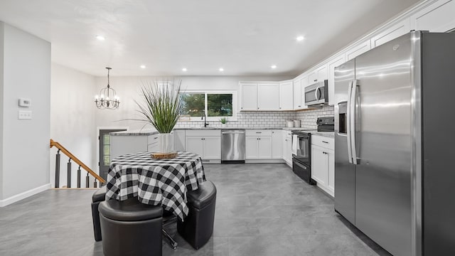 kitchen with pendant lighting, stainless steel appliances, backsplash, white cabinets, and light stone countertops