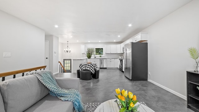 living area with a notable chandelier, concrete floors, recessed lighting, and baseboards