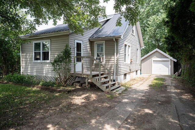 942 Lenox Ave, Mansfield, OH 44906 - view of front of property with asphalt driveway, an outbuilding, a detached garage, and a metal roof