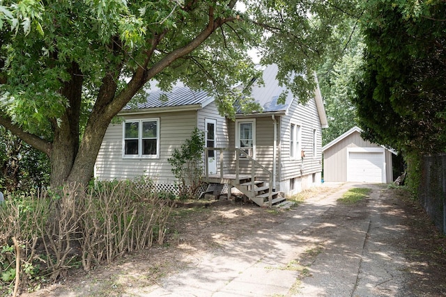 942 Lenox Ave, Mansfield, OH 44906 - view of front facade with driveway, an outbuilding, a detached garage, and a metal roof
