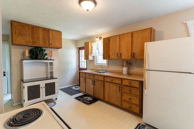 942 Lenox Ave, Mansfield, OH 44906 - kitchen featuring freestanding refrigerator, brown cabinetry, light countertops, and light floors