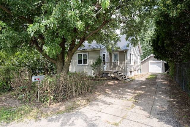 942 Lenox Ave, Mansfield, OH 44906 - view of front of property with driveway, an outbuilding, a detached garage, and a metal roof