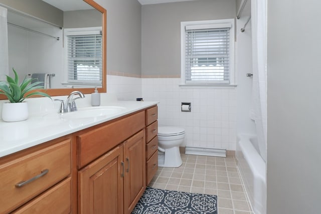 bathroom with tile patterned floors, toilet, vanity, tile walls, and shower / bath combo