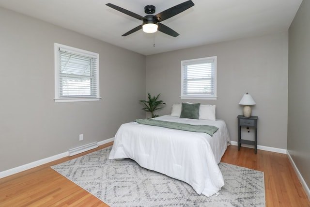 bedroom featuring wood finished floors, visible vents, baseboards, and ceiling fan