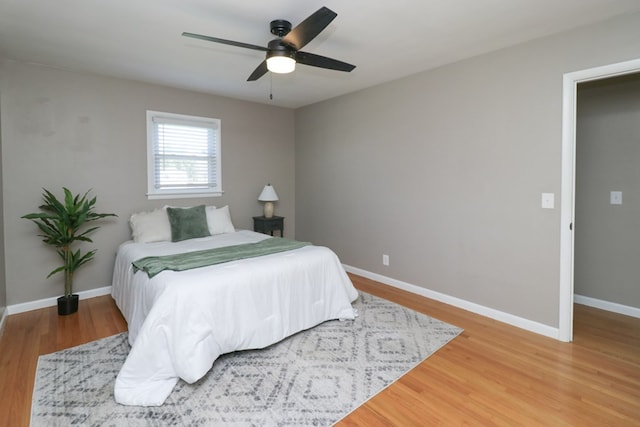 bedroom with baseboards, a ceiling fan, and light wood-type flooring