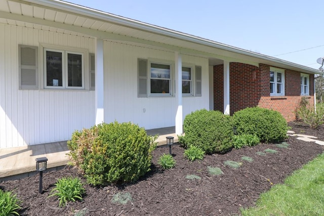 entrance to property with brick siding and covered porch