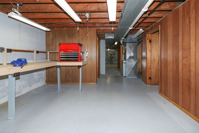 unfinished basement featuring heating unit and wooden walls