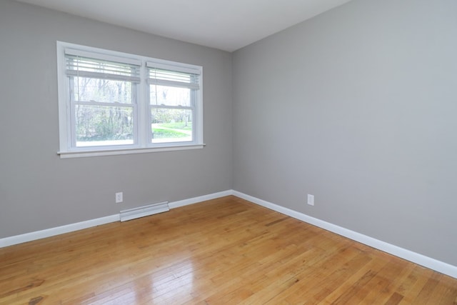 unfurnished room with light wood-type flooring, baseboards, and visible vents