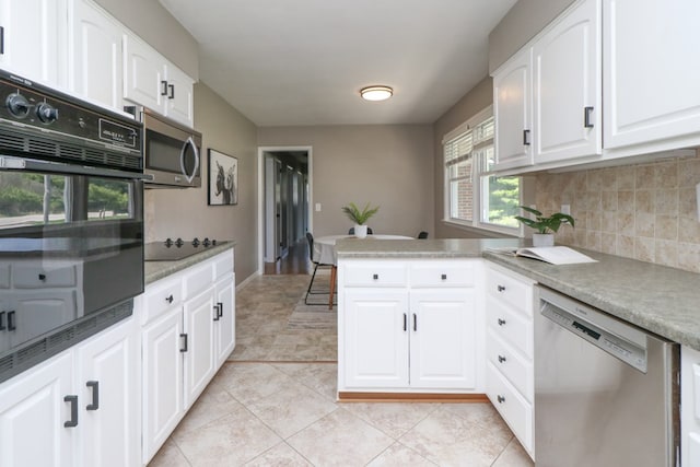 kitchen featuring backsplash, a peninsula, white cabinetry, and black appliances