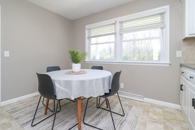dining room featuring a baseboard radiator, a wealth of natural light, and baseboards