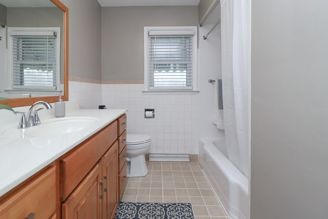bathroom featuring tile patterned floors, vanity, tile walls, a wainscoted wall, and toilet