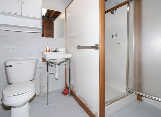 bathroom featuring a shower stall, concrete floors, toilet, and a sink