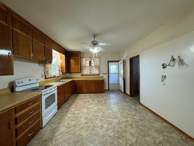 kitchen with white electric range oven, ceiling fan, a wealth of natural light, and sink