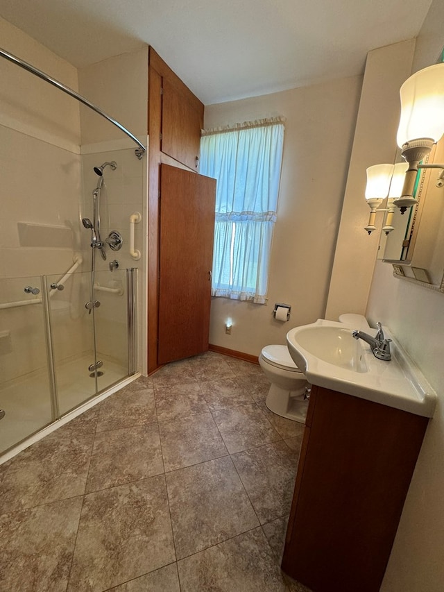 bathroom with vanity, toilet, and a shower with door