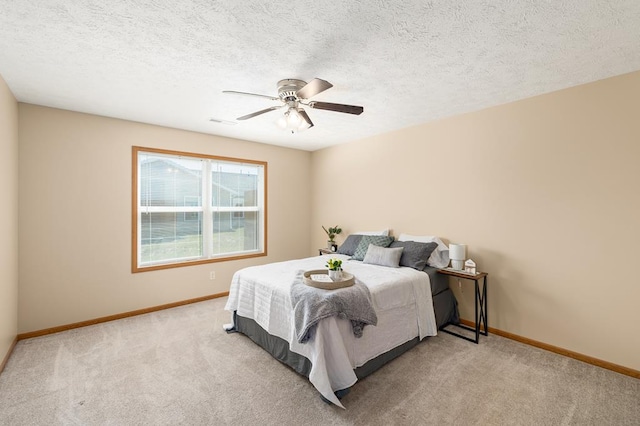 carpeted bedroom with a ceiling fan, baseboards, visible vents, and a textured ceiling