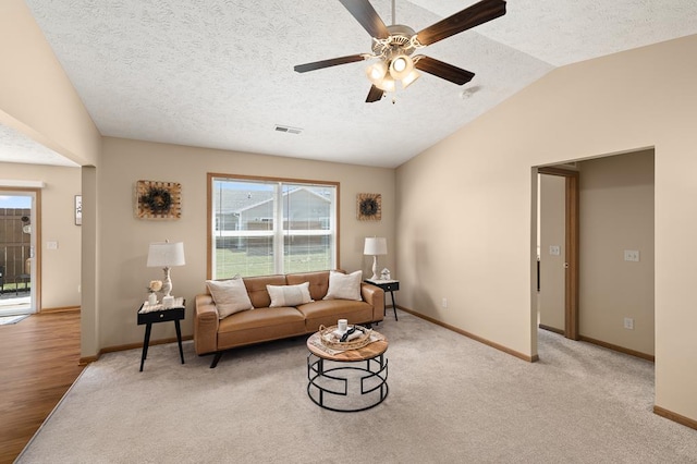 living room with a textured ceiling, ceiling fan, visible vents, and baseboards