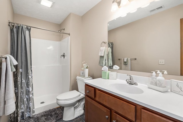bathroom with visible vents, a stall shower, toilet, and vanity