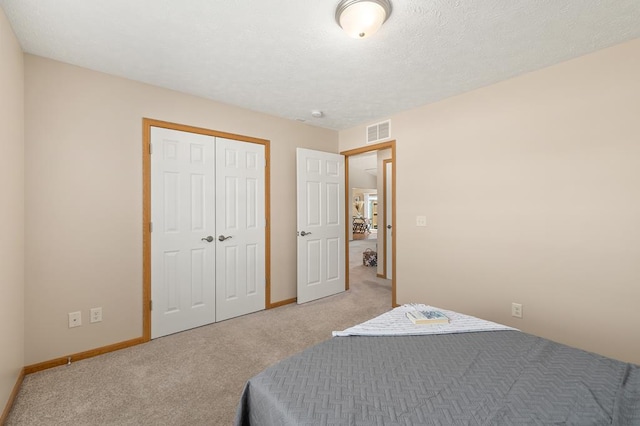 bedroom with visible vents, baseboards, a closet, and light colored carpet