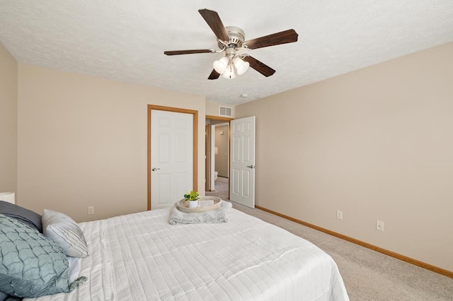 bedroom featuring visible vents, light carpet, baseboards, a textured ceiling, and a ceiling fan