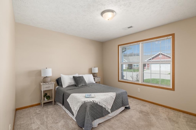 bedroom with baseboards, carpet, a textured ceiling, and visible vents