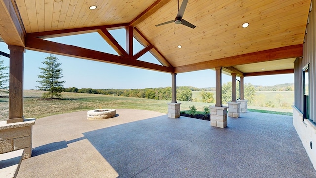 view of patio featuring ceiling fan, a rural view, and a fire pit