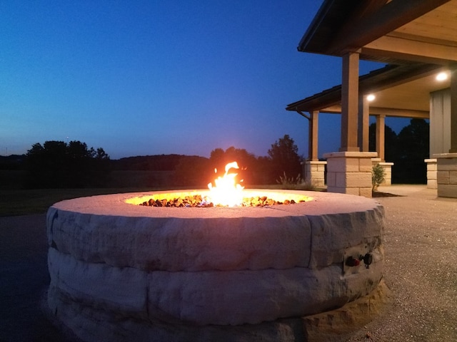 pool at dusk featuring a fire pit