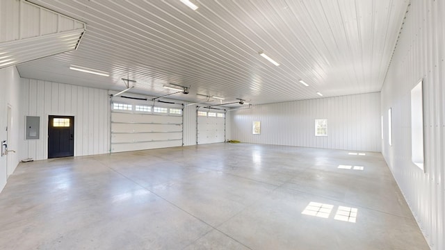 garage with electric panel and wood walls