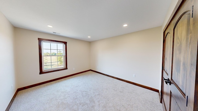 unfurnished room featuring light colored carpet