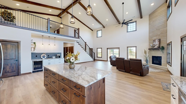 kitchen with tasteful backsplash, a towering ceiling, beverage cooler, and a kitchen island