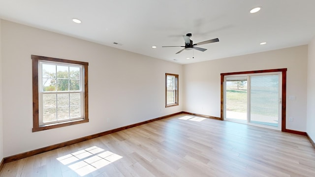 unfurnished room with ceiling fan, a healthy amount of sunlight, and light wood-type flooring