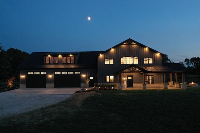 modern inspired farmhouse with a garage and a lawn