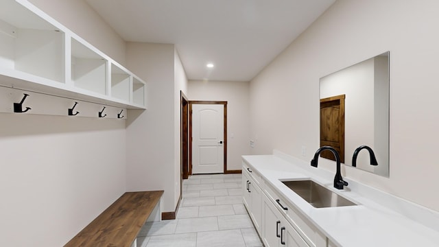 mudroom with light tile patterned floors and sink