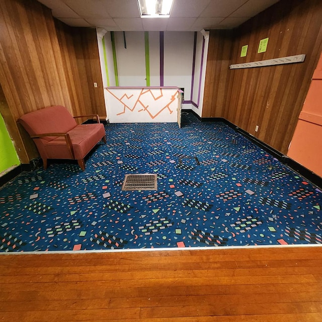 233 E Mansfield St, Bucyrus, OH 44820 - interior space featuring baseboards, a paneled ceiling, carpet floors, and wooden walls