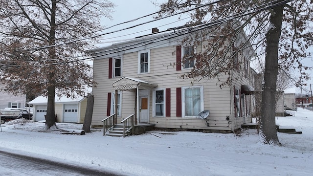 view of front of house with a garage and an outdoor structure