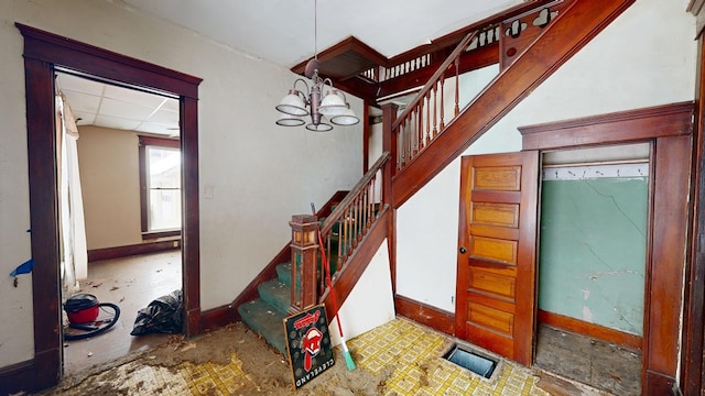 stairway featuring a chandelier