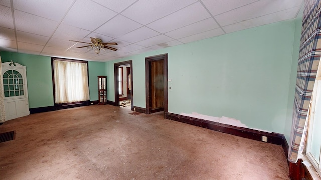 spare room featuring concrete flooring, a drop ceiling, and ceiling fan