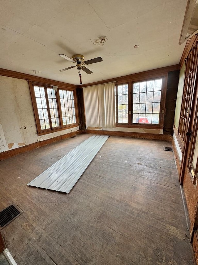 unfurnished sunroom with visible vents and ceiling fan