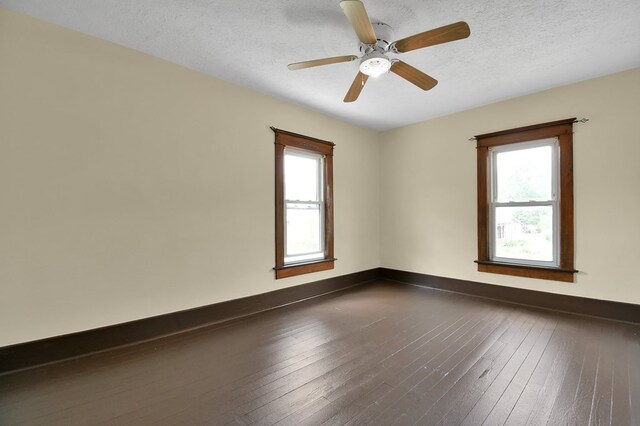 97 S Gamble St, Shelby, OH 44875 - spare room with healthy amount of natural light, dark wood-type flooring, baseboards, a ceiling fan, and a textured ceiling