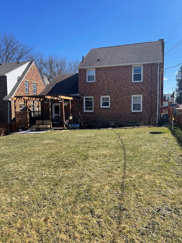 back of property featuring a patio area, a lawn, a pergola, and brick siding