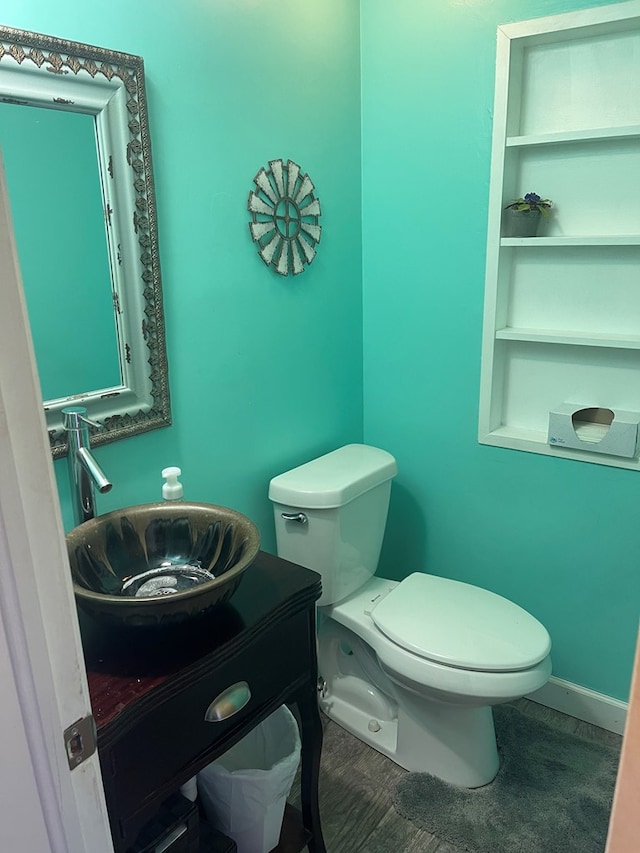 bathroom with vanity, toilet, and baseboards