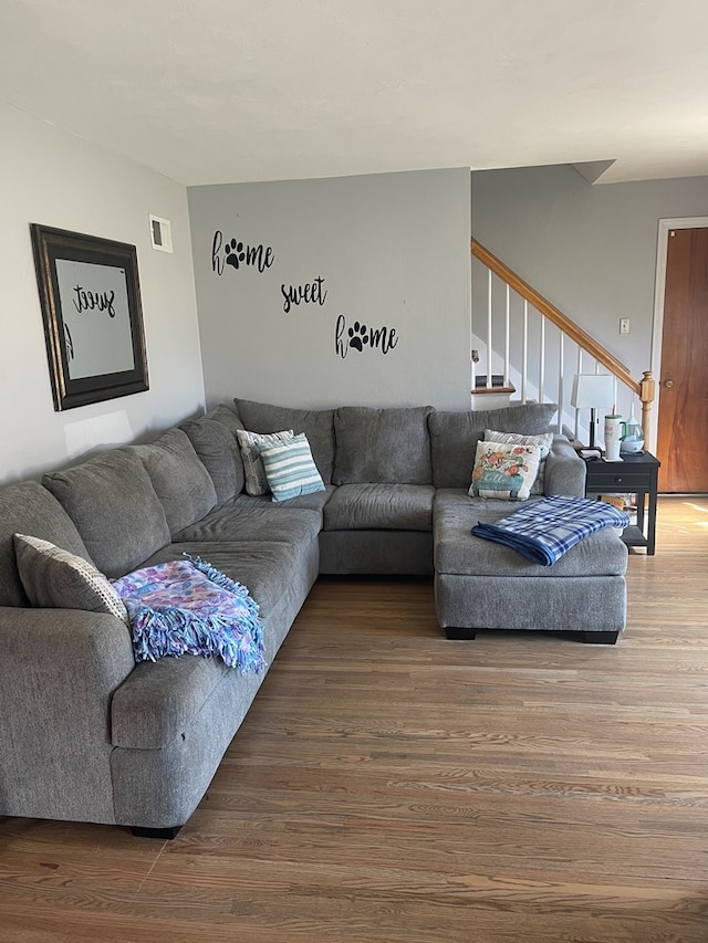 living room with visible vents, wood finished floors, and stairs