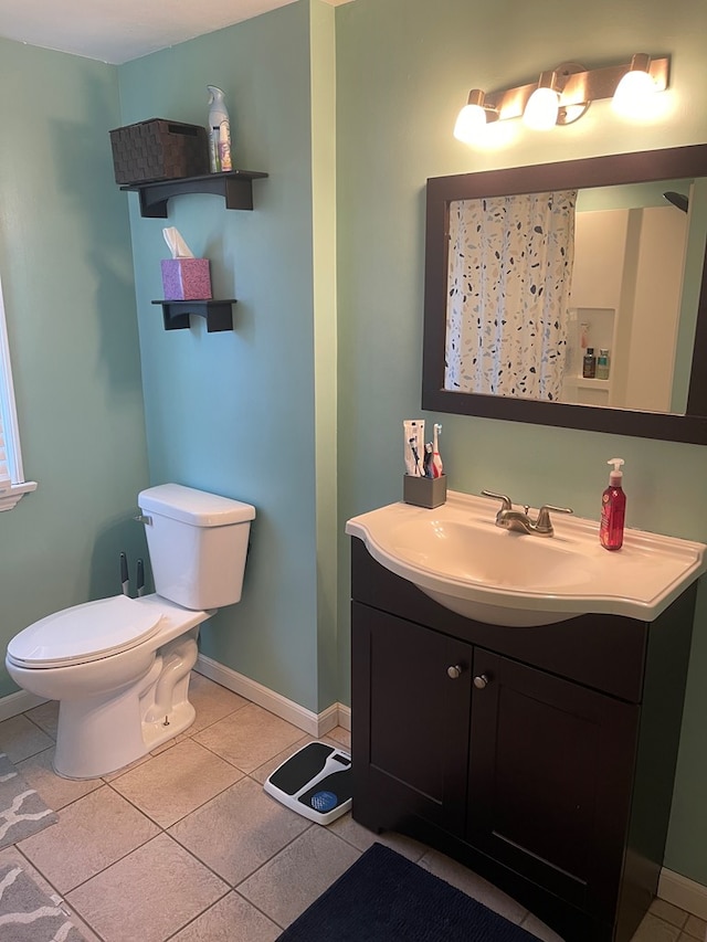 bathroom featuring vanity, tile patterned floors, toilet, and baseboards