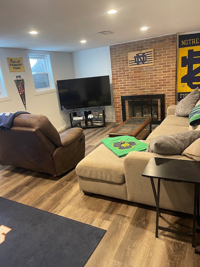 living room with recessed lighting, wood finished floors, and a fireplace