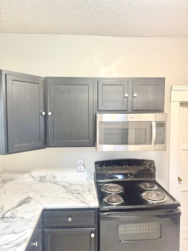 kitchen featuring black range with electric stovetop, light stone countertops, and a textured ceiling