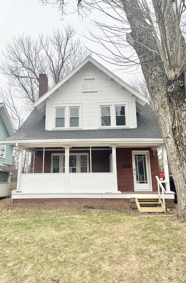 view of front of property with a front yard and covered porch