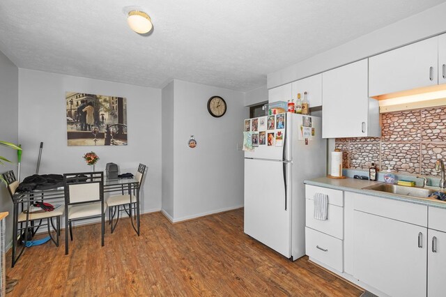 524.526 Rudy Rd, Mansfield, OH 44903 - kitchen featuring a sink, freestanding refrigerator, wood finished floors, white cabinetry, and light countertops